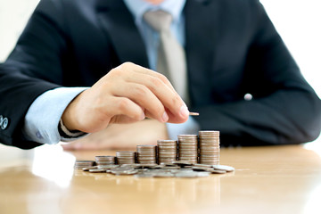 Hand putting stack of coins