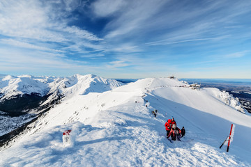 Fototapeta na wymiar Tourists climb on one of the peaks of high Tatras