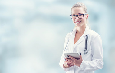 Young doctor woman smile face with tablet stethoscope and white coat