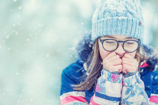 Young Girl In Winter Clothes Warming Her Cold Hands