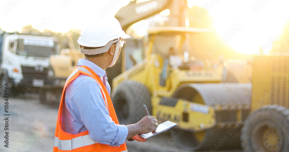 Aufkleber asian engineer with hardhat using tablet pc computer inspecting and working at construction site
