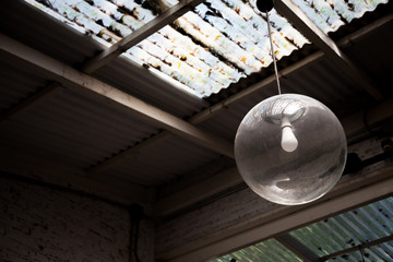 Round spherical lamps are hung inside the building. Under the zinc is covered with leaves.