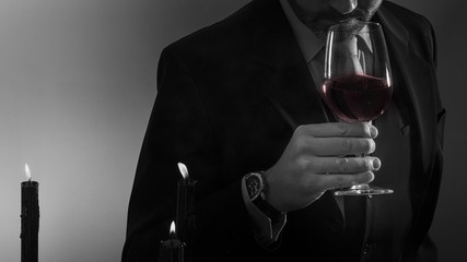 man drinking a glass of red wine