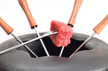 Fondue Topf mit klein Stück Rindfleisch auf Gabel Nahaufnahme