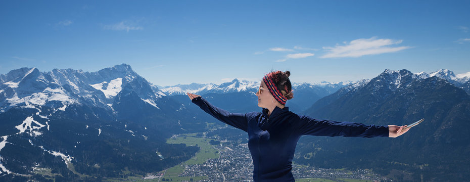 junge Frau macht Gymnastikübungen in den Bergen, Blick zur Zugspitze und ins Tal