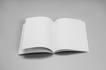 Mock-up magazine, book or catalog on gray table. Blank page or notepad on solid background. Blank page or notepad for mockups or simulations.