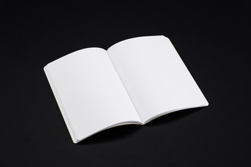 Mock-up magazine, book or catalog on black table. Blank page or notepad on solid background. Blank page or notepad for mockups or simulations.