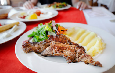 Plate with tasty mashed potatoes, fried meat and salad on table, closeup
