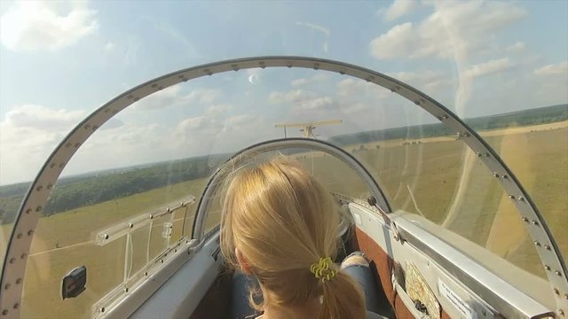 The glider flying. Woman in cabin of the glider.