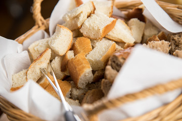 Fonduegabeln in Brotkorb mit Brotwürfeln aus Baguette und Vollkorn Brötchen für Käsefondue