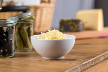 Geriebener K&auml;se, Cornichons und Oliven als Beilagen zum K&auml;se Fondue