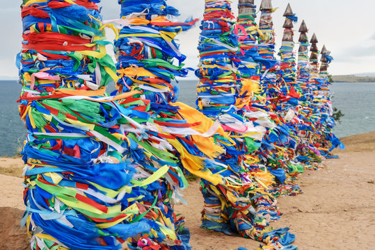 Wooden ritual pillars with colorful ribbons Hadak on cape Burkhan. Lake Baikal. Olkhon Island. Russia