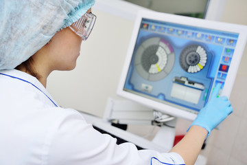 doctor or lab assistant presses the touch screen monito