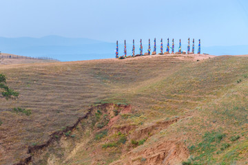 Wooden ritual pillars with colorful ribbons Hadak on cape Burkhan. Lake Baikal. Olkhon Island. Russia