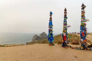 Fototapeta premium Wooden ritual pillars with colorful ribbons Hadak on cape Burkhan. Lake Baikal. Olkhon Island. Russia