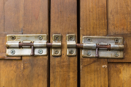 Closed lock of tool cabinet containing gardening equipment.