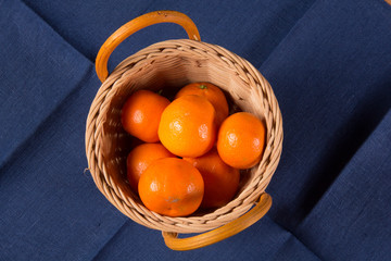 Ripe tangerines on a blue linen napkin