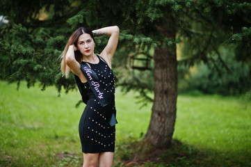 Portrait of gorgeous girl wear on black at hen party, posed at park.