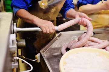 food production of sausage at a meat-packing plant. Butchers process meat