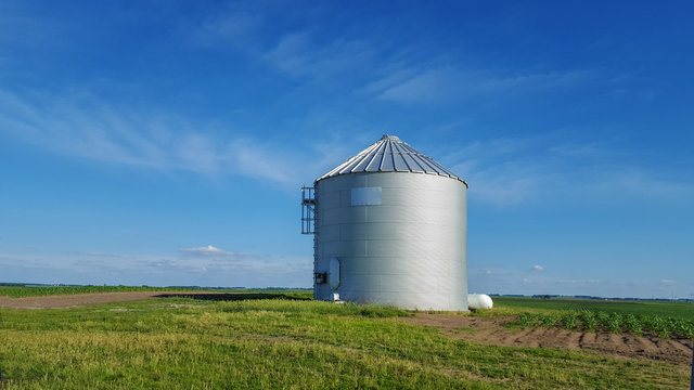 Metal silo on farmland in rural landscape