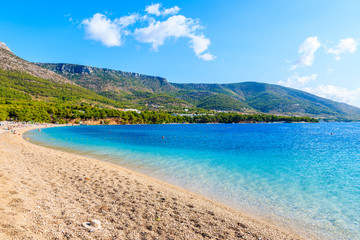 View of empty Zlatni Rat beach with beautiful sea water and mountains in background, Brac island, Croatia