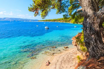 Photo sur Aluminium Plage de la Corne d'Or, Brac, Croatie Couple non identifié de personnes assises sur la plage près du célèbre cap Zlatni Rat dans la ville de Bol, île de Brac, Croatie