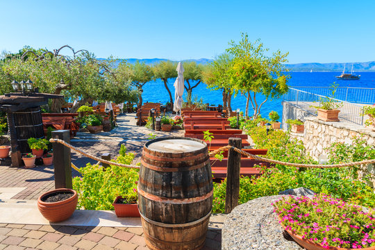 BOL TOWN, BRAC ISLAND - SEP 14, 2017: Traditional restaurant decorated with flowers and wine barrels with sea view in Bol town, Brac island, Croatia.