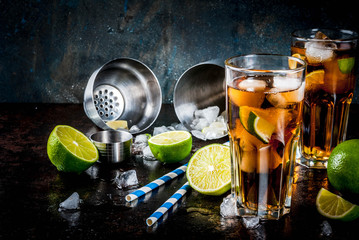 Cuba Libre, long island or iced tea cocktail with strong alcohol, cola, lime and ice, two glass, dark background copy space