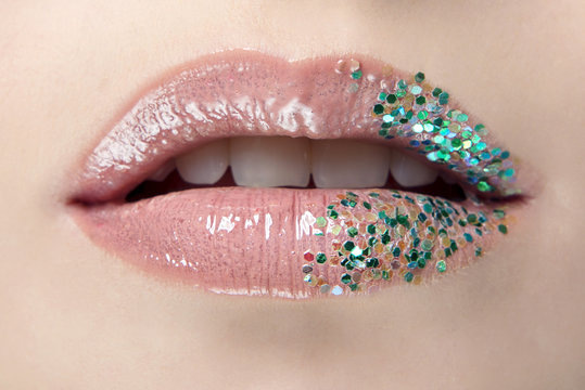Lips with pink lipstick and green glitter in glamour close-up