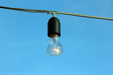 burning lamp on the background of blue sky.