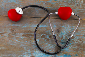 Stethoscope with red heart on a wood background