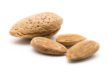 Almonds three shelled nuts and unshelled one isolated on white background.