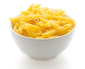 Penne rigate in porcelain bowl isolated on white background dry raw pasta pieces.