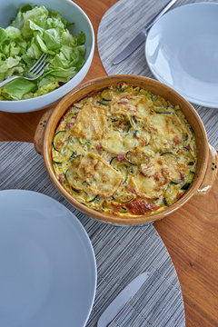 Zucchini Flan Served On a Wooden Table Dressed With Salad Bowl and Soufflenheim Pottery
