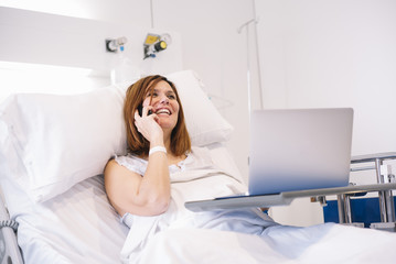 ill woman with Smartphone and laptop in the hospital