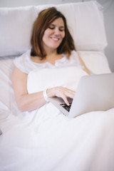 Obraz na płótnie Canvas woman ill with laptop in the hospital
