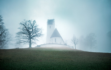 creepy halloween church or chapel on hill in Bavaria in fog or mist