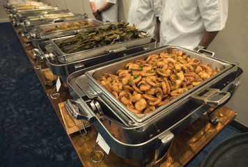 large tray of shrimp and other dishes at a large catered banquet buffet