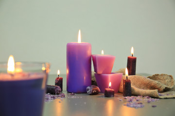 Purple burning candles on table