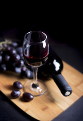 chalice wine and grapes on the wood with bottle