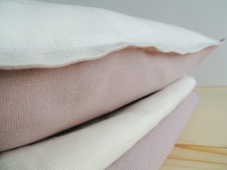 Natural linen handmade white pink pillow cover, pillowcase, cushion on linen sheet.