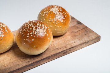 Cooking bread buns for burger on wooden table white isolated background.