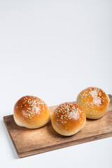 Cooking bread buns for burger on wooden table white isolated background.