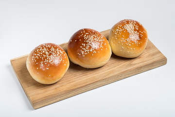 Cooking bread buns for burger on wooden table white isolated background.