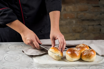 Cooking fresh hamburger buns with sesame seeds. Delicious butter cakes. Fast food concept.