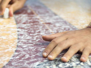 Surfer rubs the wax into the board