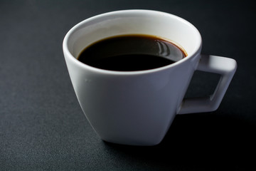 White cup of coffee on black background