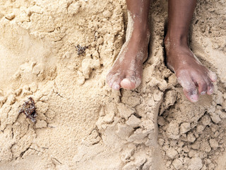 Female tanned legs in the sand