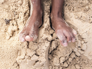 Female tanned legs in the sand