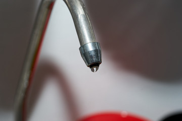 Tap closeup with dripping water-drop. Water leaking, saving concept.
